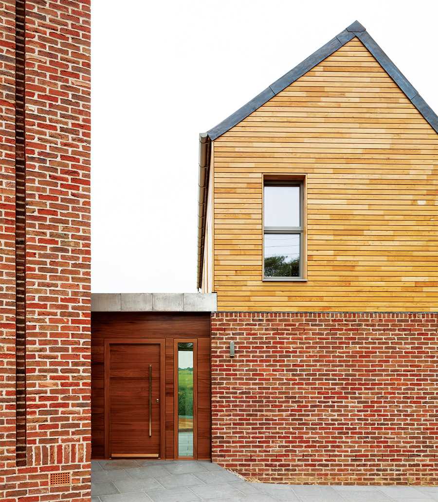 A combination of Sussex chestnut cladding and handmade bricks clad the exterior walls, while the front door is fully passive house certified, from Urban Front