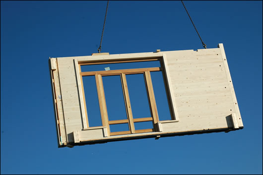 A section of the Glulam wall and doors been hoisted into place