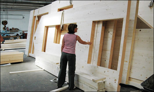 Carol Daly examining solid wood walls at the Riko factory in Slovenia
