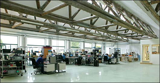 Timber trusses dominate the extensively glazed north-facing factory floor, which was polished mechanically, thus avoiding the use of any chemical products or additional materials