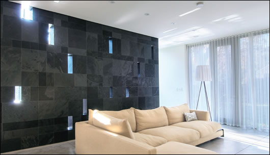 the slate wall acts as a thermal store yet allows shafts of daylight through