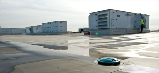 Inlets for the rainwater harvesting system with air handling units in the background. Rainwater is harvested, chlorinated and used in public toilets and to irrigate the landscape