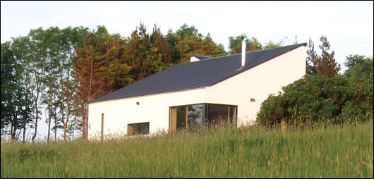 The house partially obscured by a meadow