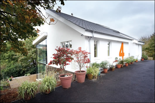 a vernacular white-render-and-slate look was used at the front of the house