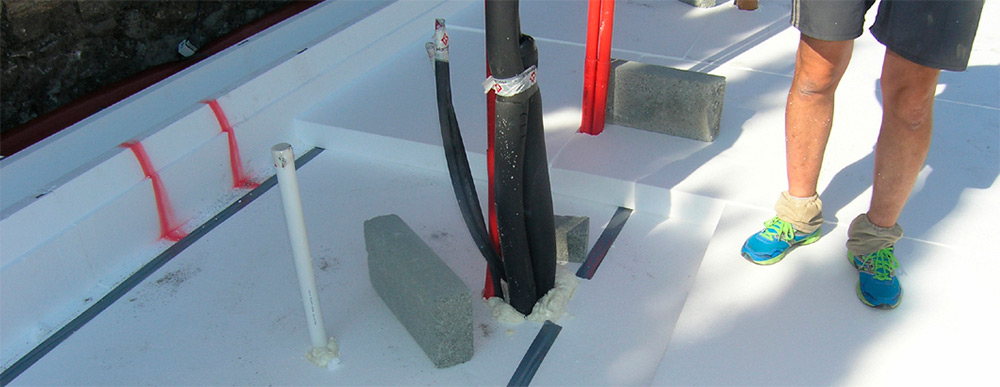 The Supergrund foundation system features three layers of EPS 100 insulation, with the bottom layer shown here with joints taped, and foam filling around service penetrations