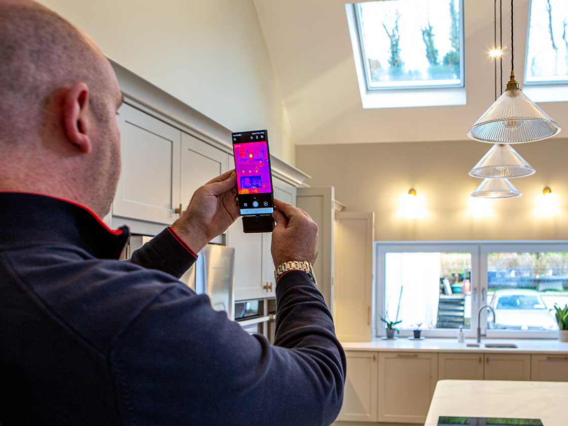 McCarron using a thermal imaging camera phone in the finished home.