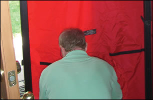 A blower door unit being fitted to conduct an air pressurisation test on a dwelling