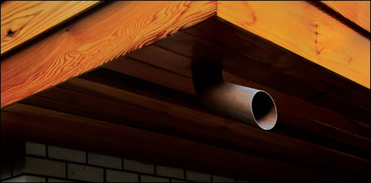 Non-traditional down-pipes adorn the exterior of the house. Instead of running to the ground, the pipes extend only a short distance