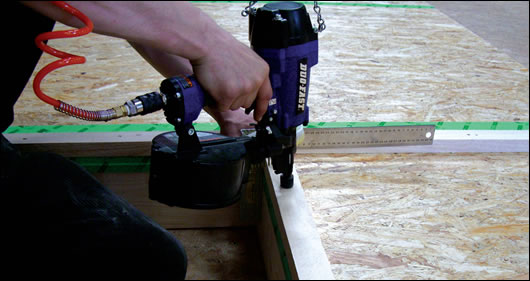 A worker in Continental Homes’ factory building timber sections with nails and thereby reducing the use of glues