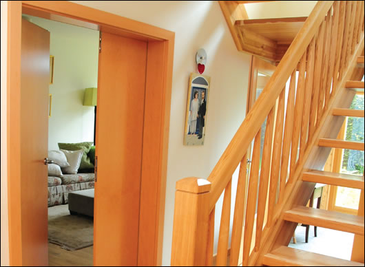 the entrance hall looking south towards the sun room (behind the timber stairs) with the living room to the left