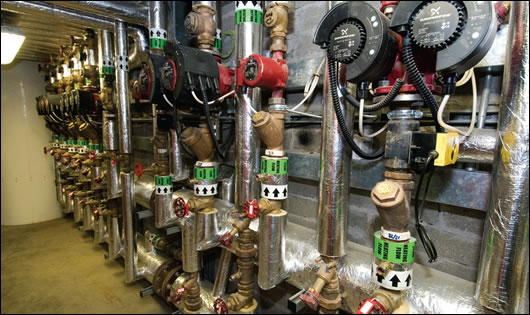 a view of some of the system’s pumps and pipes, with the preheat tank in the background