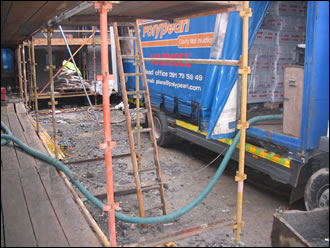 Warm cellulose insulation, made from recycled newspapers is delivered to site